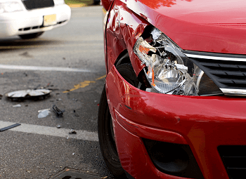 Red sedan with a broken headlight from a crash